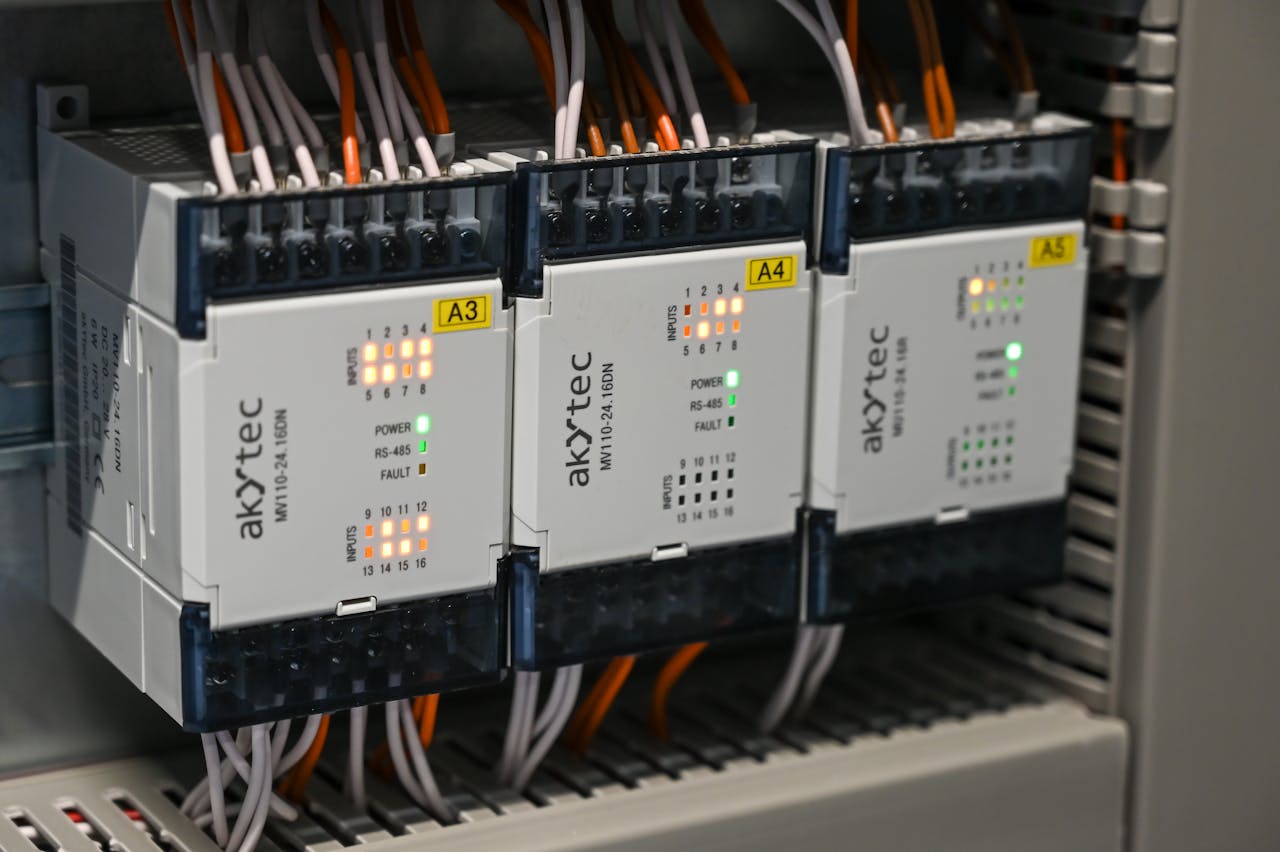 about-img Close-up of industrial control boxes with wires and lights.